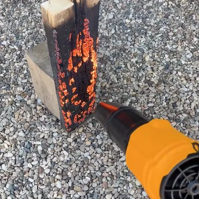 The SuperLeafBlower blowing on a glowing log to get a fire going
