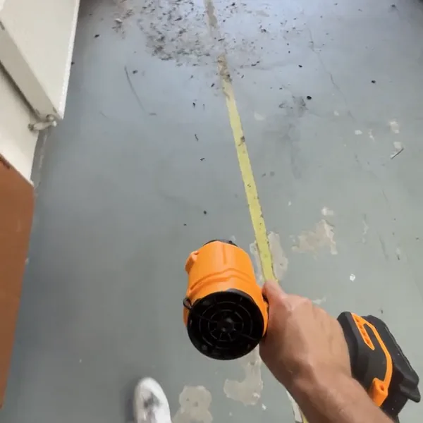 SuperLeafBlower blowing dust across a garage floor toward the open door